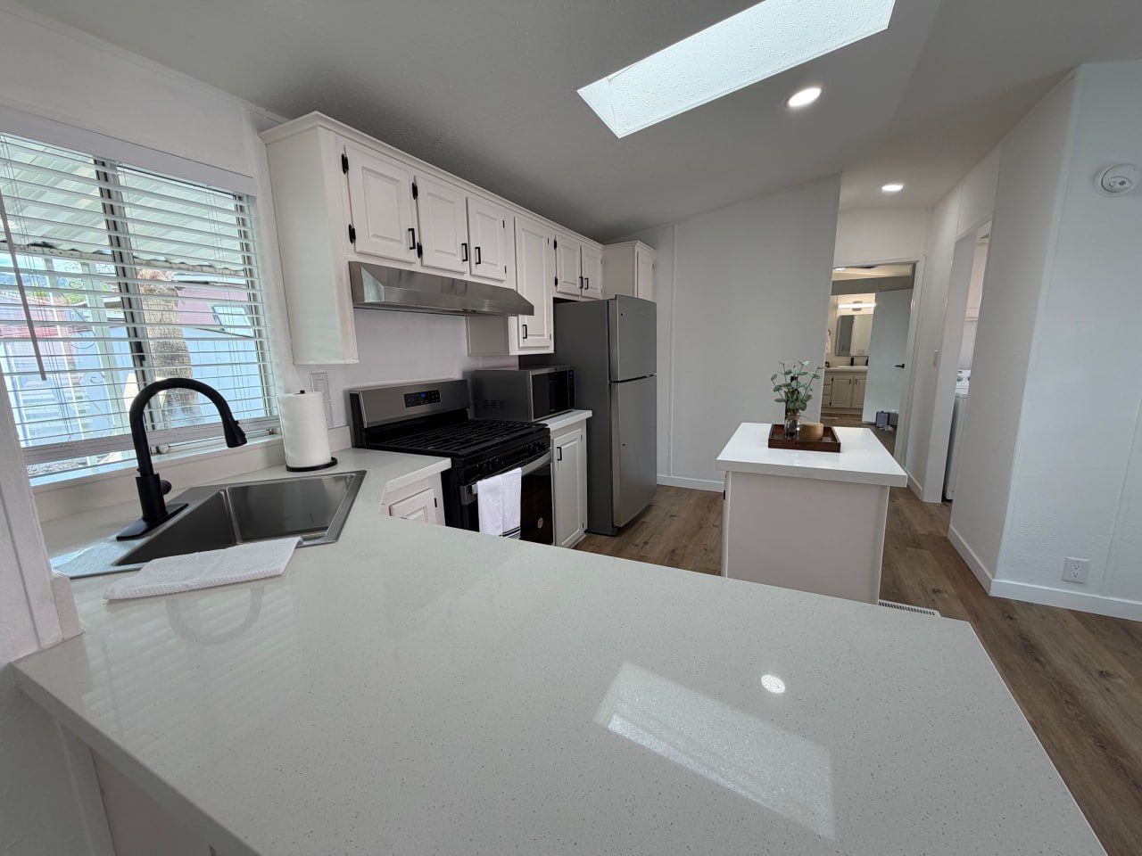 Renovated mobile home kitchen with quartz countertops and island